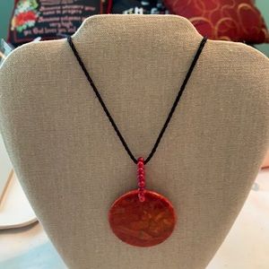 Black cord holds a like lg piece of coral